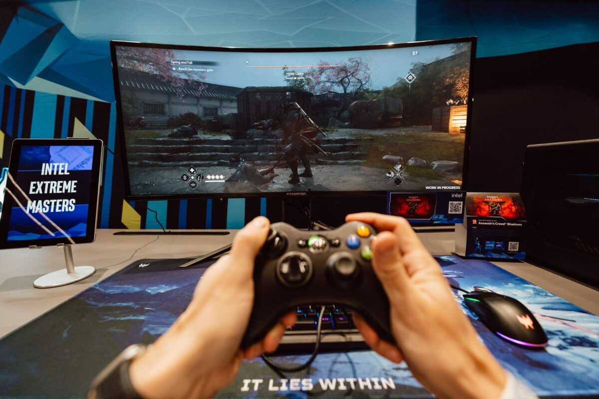 Dłonie z padem przed monitorem na stoisku Acer Predator podczas IEM Katowice 2025