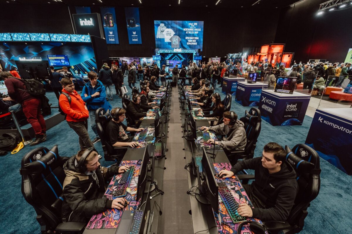 Rzędy stanowisk gamingowych pełne graczy w strefie Intel na IEM Katowice 2025